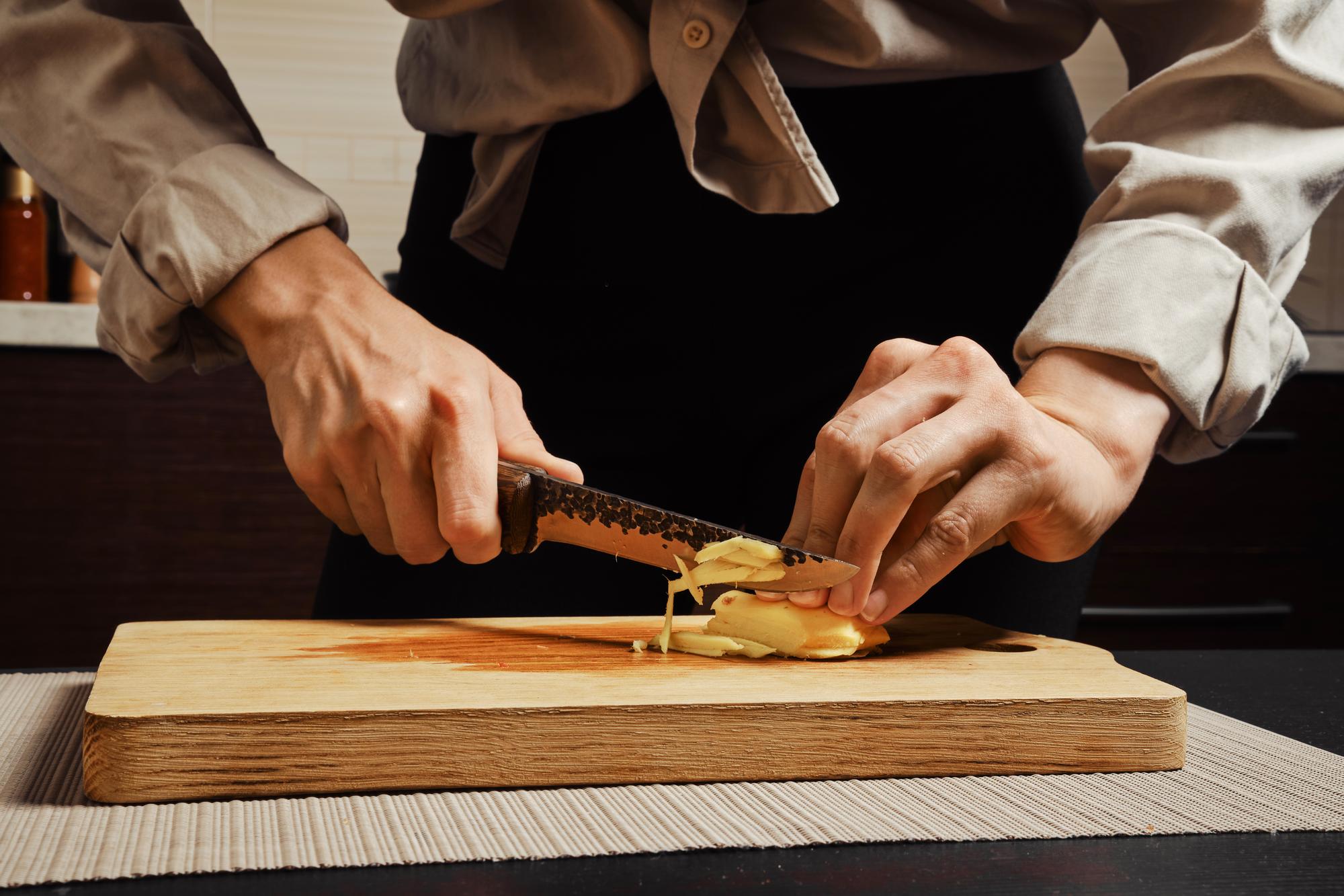 Instructor demonstrating knife technique over wooden board